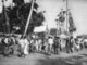 Thailand: A festival procession enters the front gates of Wat Phra That Haripunchai, Lamphun (c. 1920)